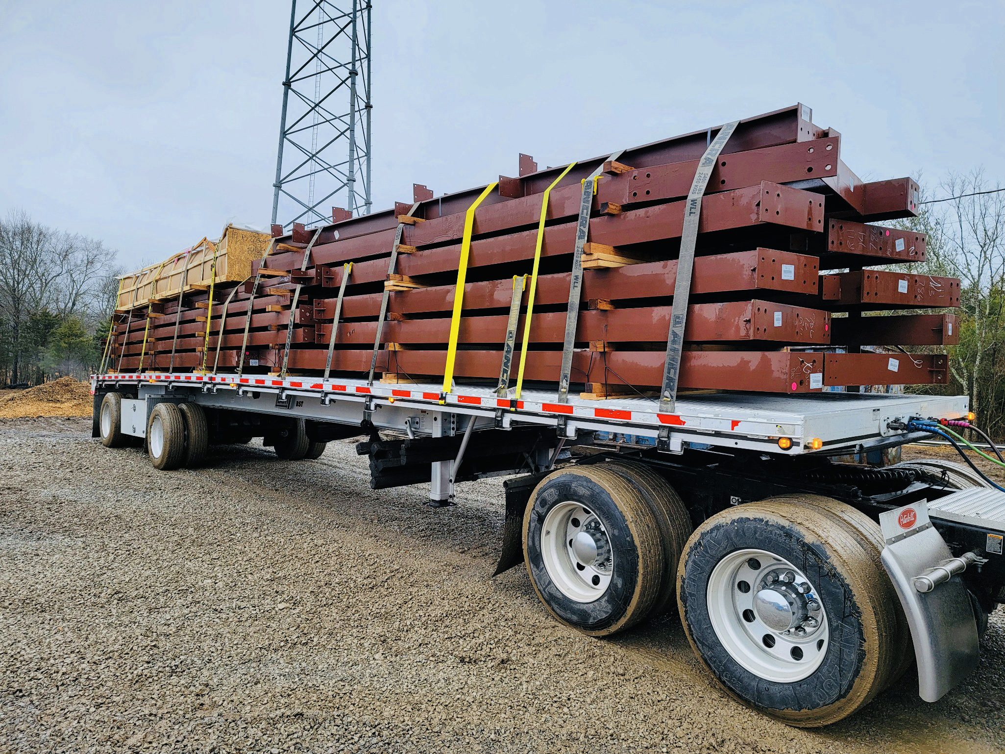 A large truck with several stacks of steel beams on it's trailer.