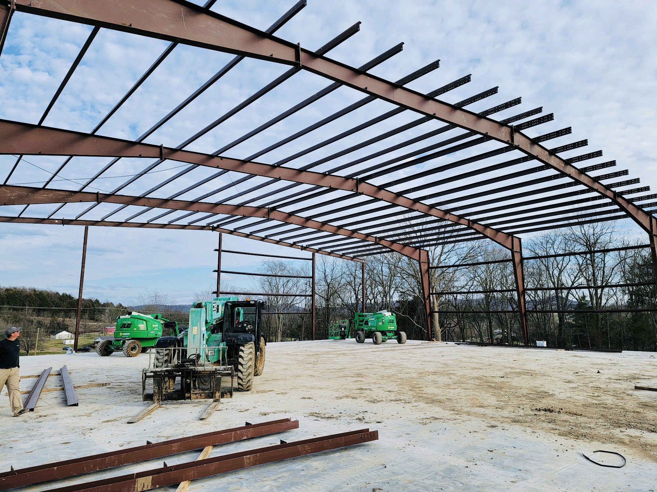 A large metal structure with many green tractors.