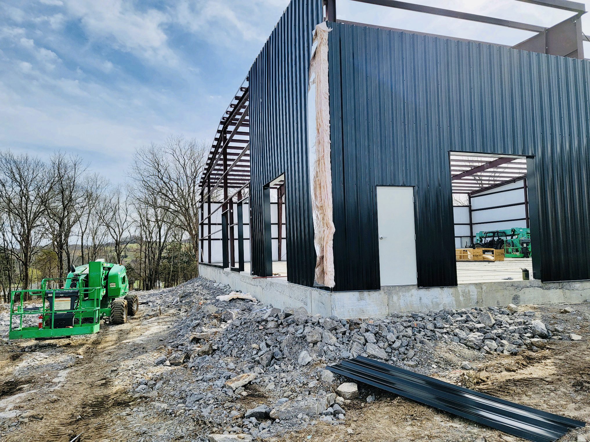 A building being built with workers standing around.