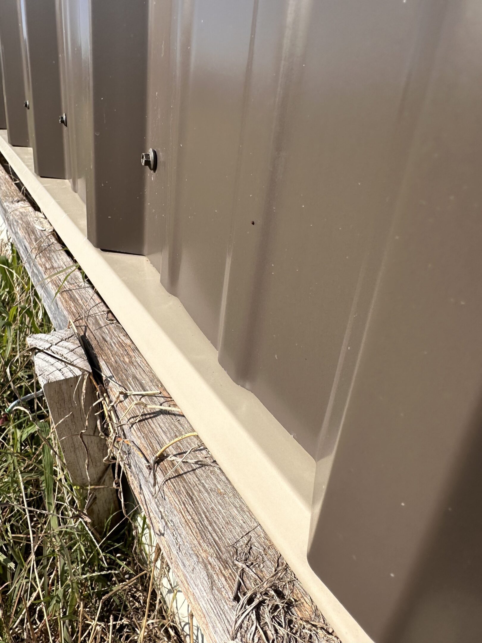 A fence that has been painted white and is being boarded up.