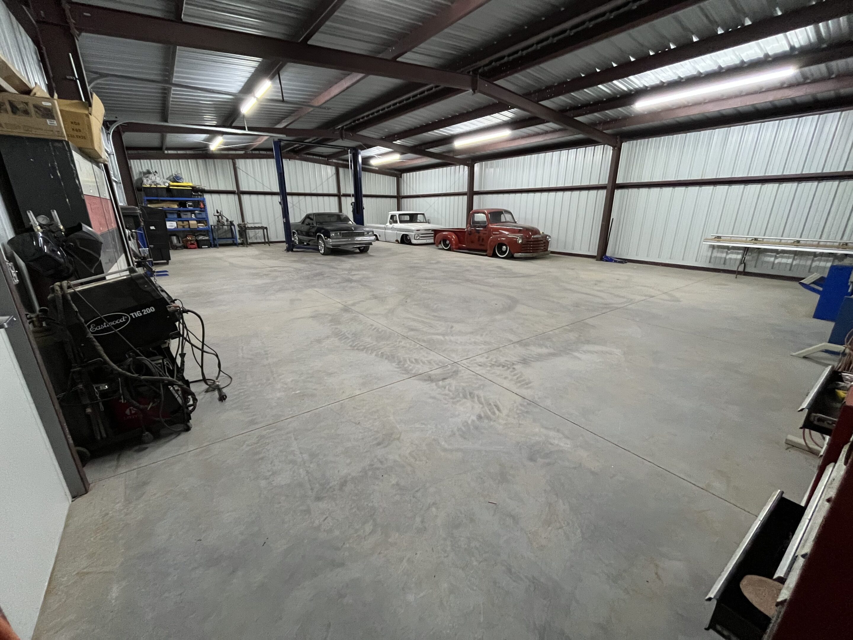 A large warehouse with many cars parked in it.