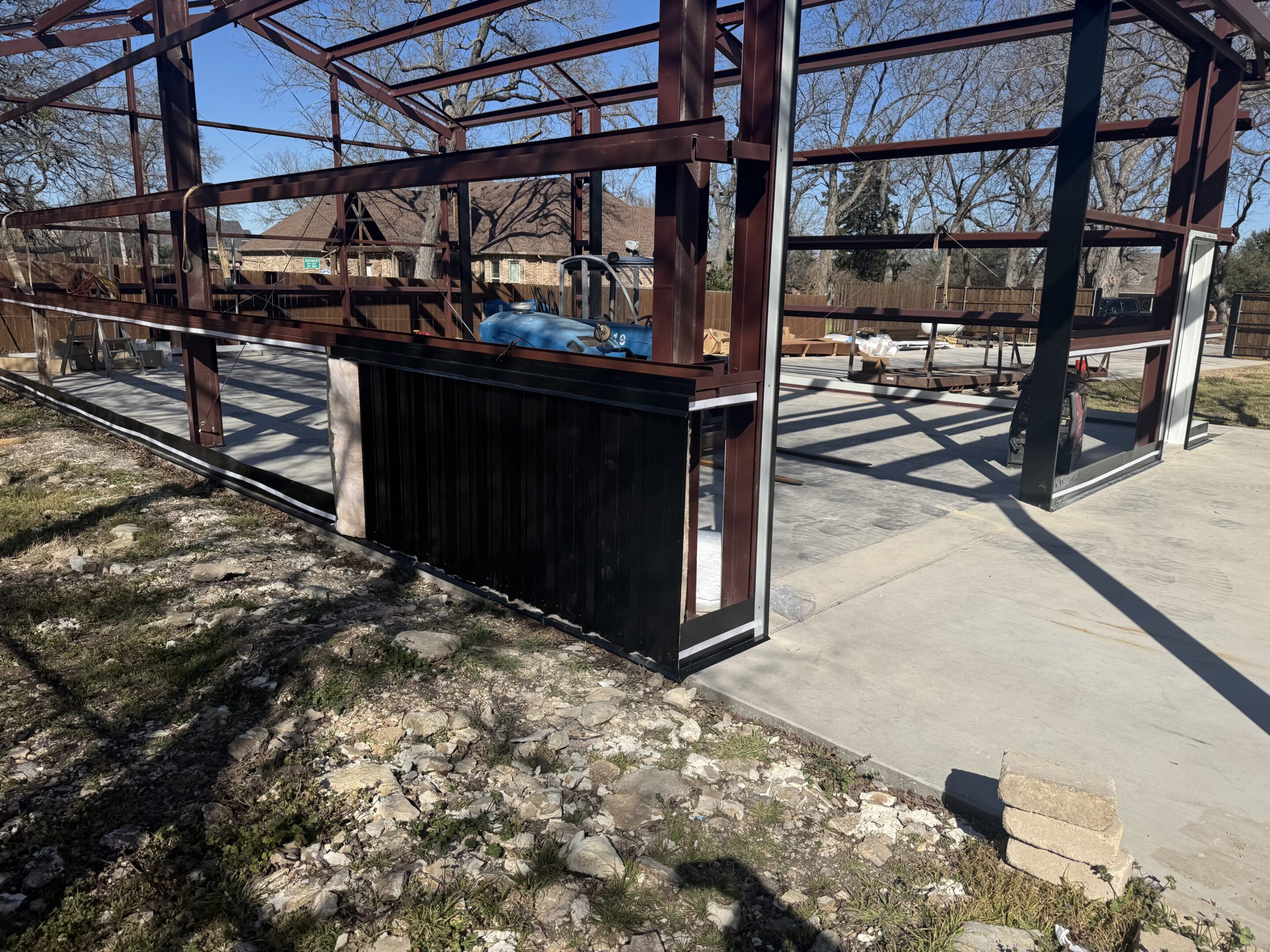 A metal structure with some concrete on the ground