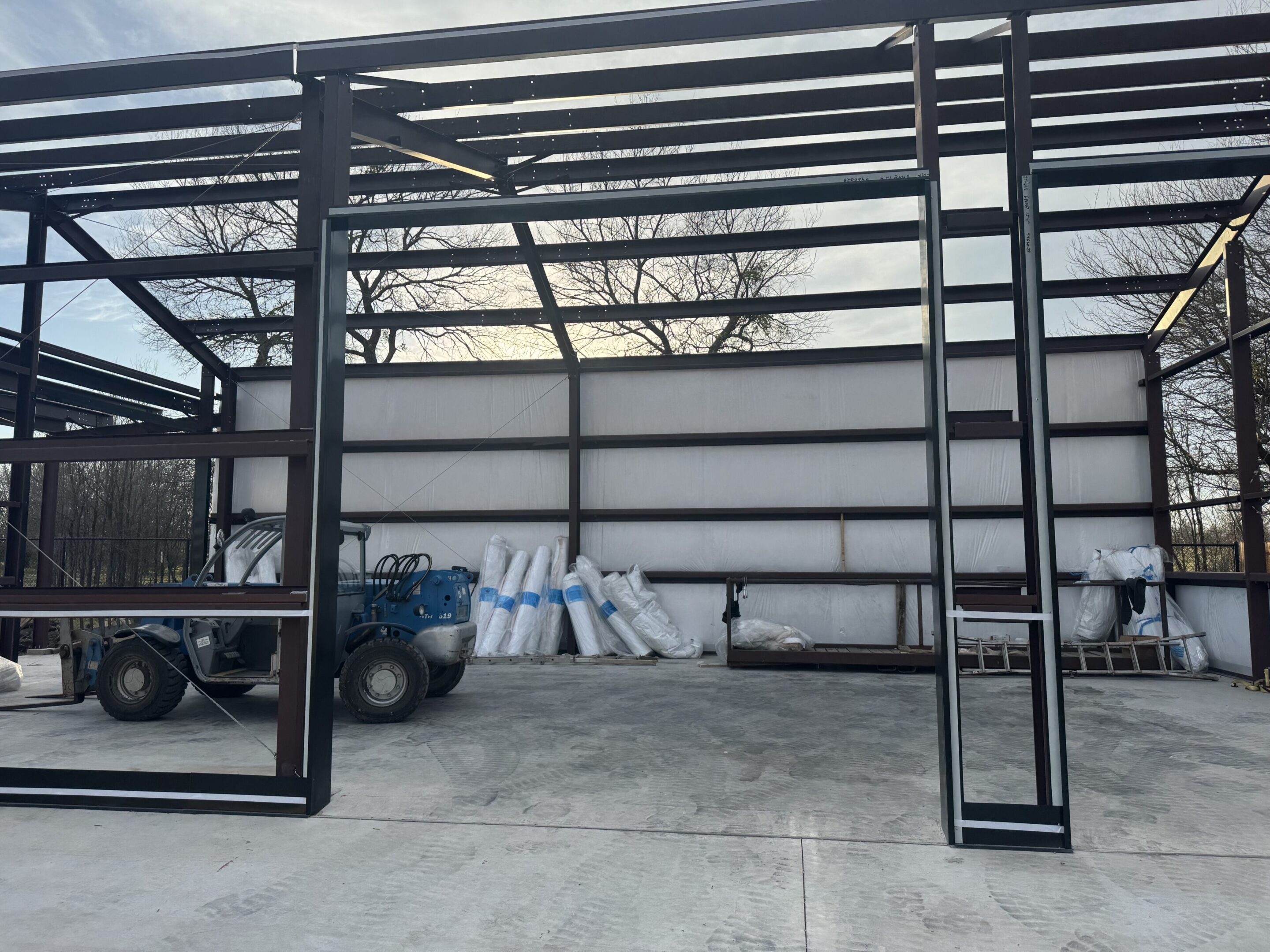 A large metal building with a truck parked in it.