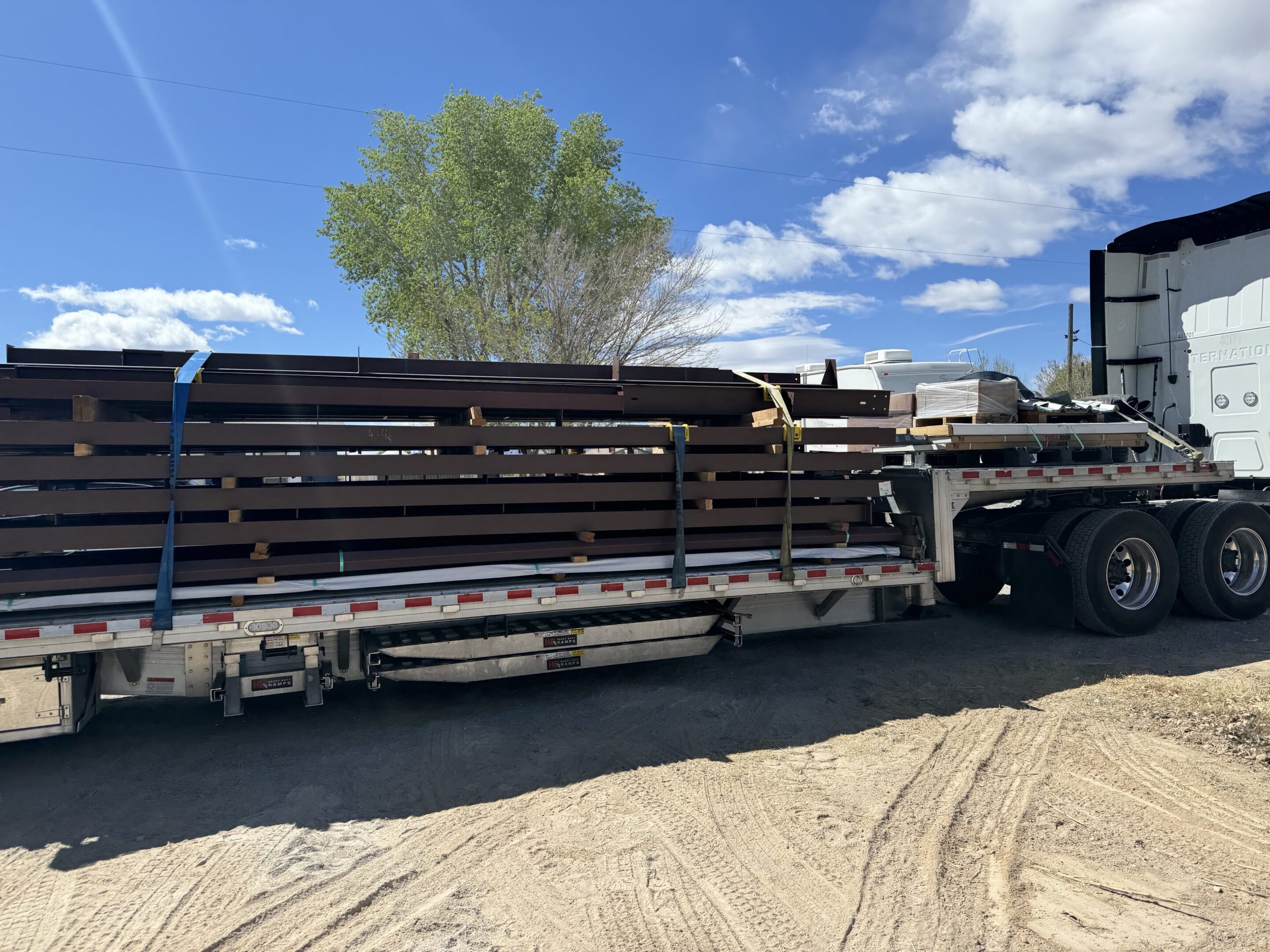 A truck with several large pipes on the back of it.