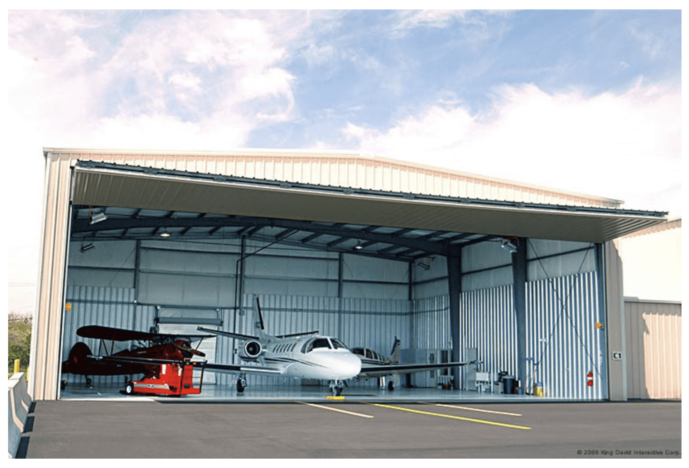 A hangar with two airplanes parked in it.
